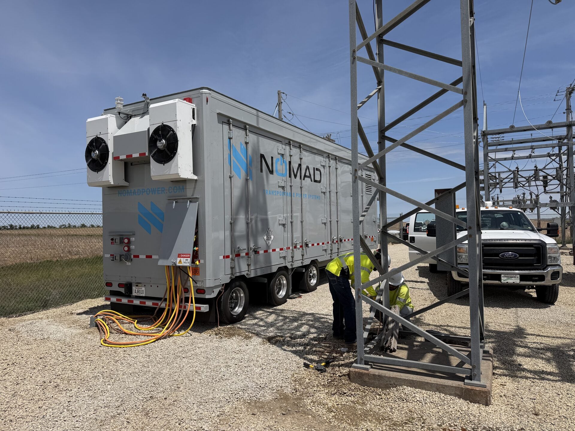 Mobile battery energy storage unit deployed beside transmission infrastructure.