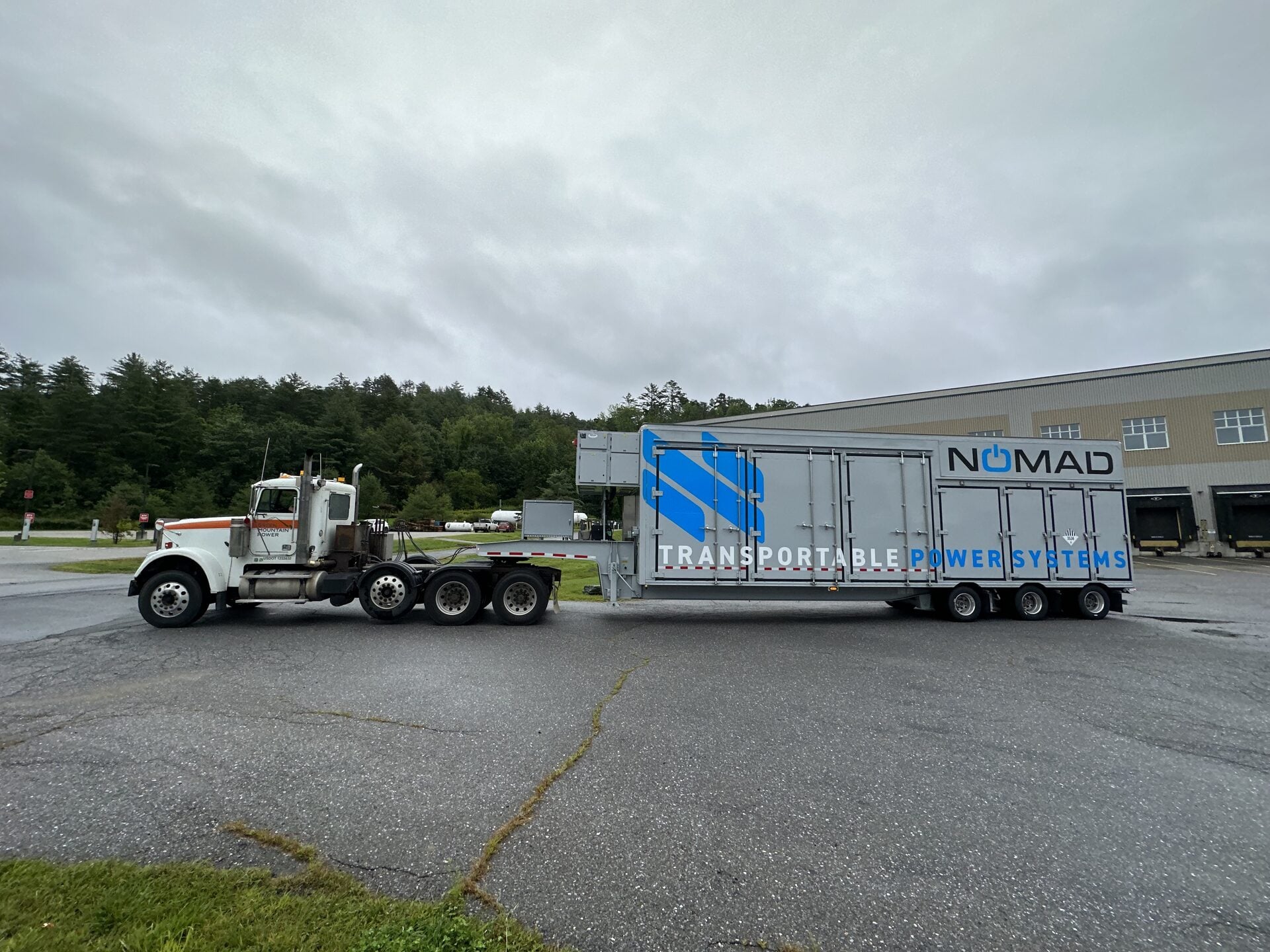 Truck hauling a NOMAD mobile battery energy storage unit to site.